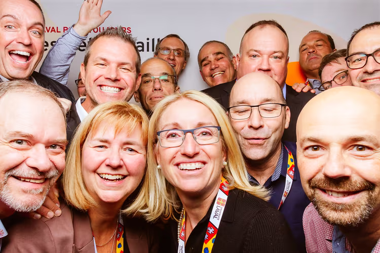 Teamfoto bei einer Veranstaltung mit lachenden Teilnehmern im Fotobox-Stil Gruppe fröhlicher Menschen bei einem Event, aufgenommen in einer Fotobox mit Nahaufnahme