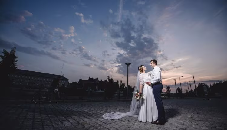 a bride and groom standing on a cobblestone road