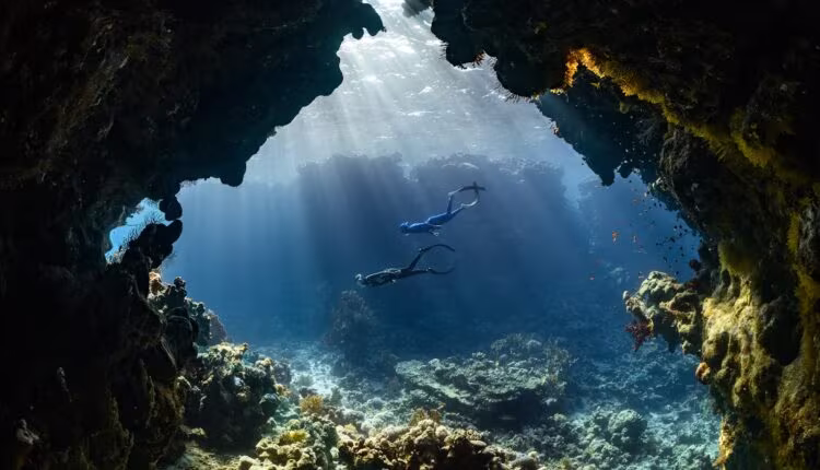 a scuba diver swims through an underwater cave