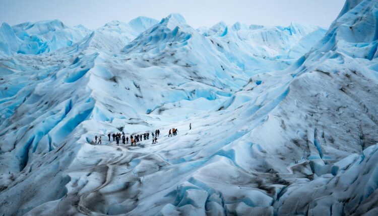 A group of people standing on top of a snow covered mountain