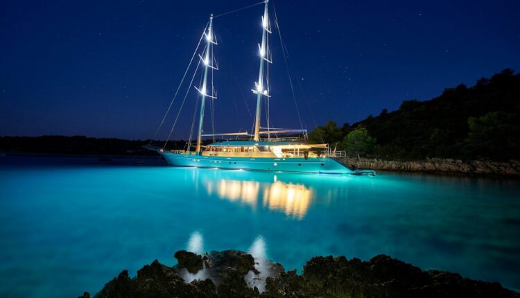brown and white sail boat on blue body of water during night time