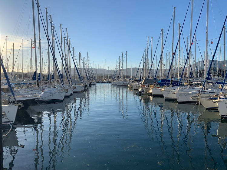 Weiße und blaue Boote an einem Steg bei Tag